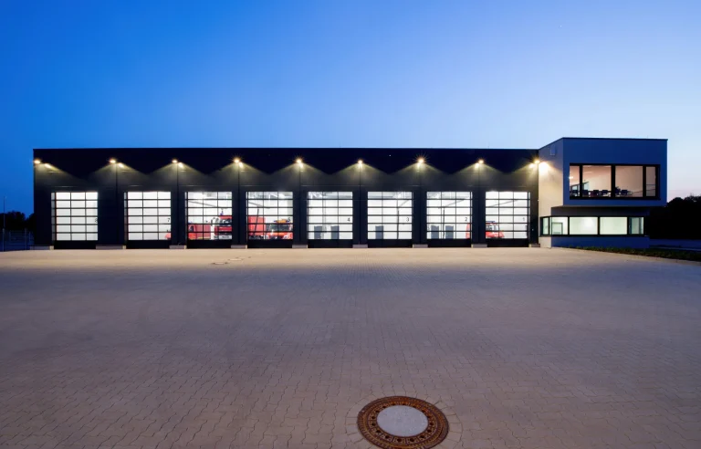 Wagenhalle der Freiwillige Feuerwehr Herne mit beleuchteter Fassade bei Dämmerung
