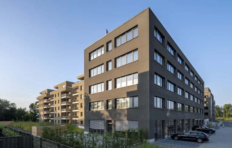 Modernes Wohngebäude mit mehreren Stockwerken und großen Fenstern bei klarem Himmel